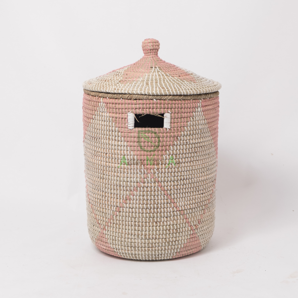Pink coiled seagrass wicker laundry hamper with cut-out handles
