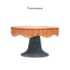 Elevate tabletop displays with our Wholesale Pedestal Tray. Handwoven from natural rattan featuring a scalloped apron, red trim accent, and dark slate grey base for HORECA buffets, corporate offices, and lifestyle retail. Bulk order ready.